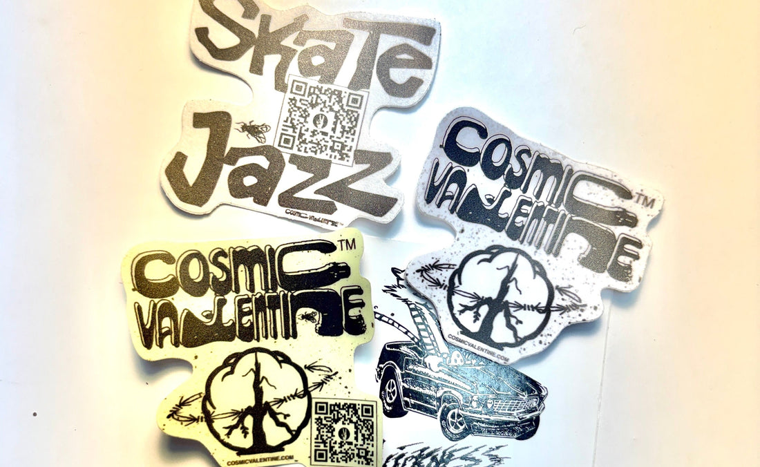 Cosmic Valentine stickers spread on a white table: a Skate Jazz sticker with a QR code, two Cosmic Valentine wordmark stickers with the tree-branch peace sign, and a black-and-white illustration of a vintage car