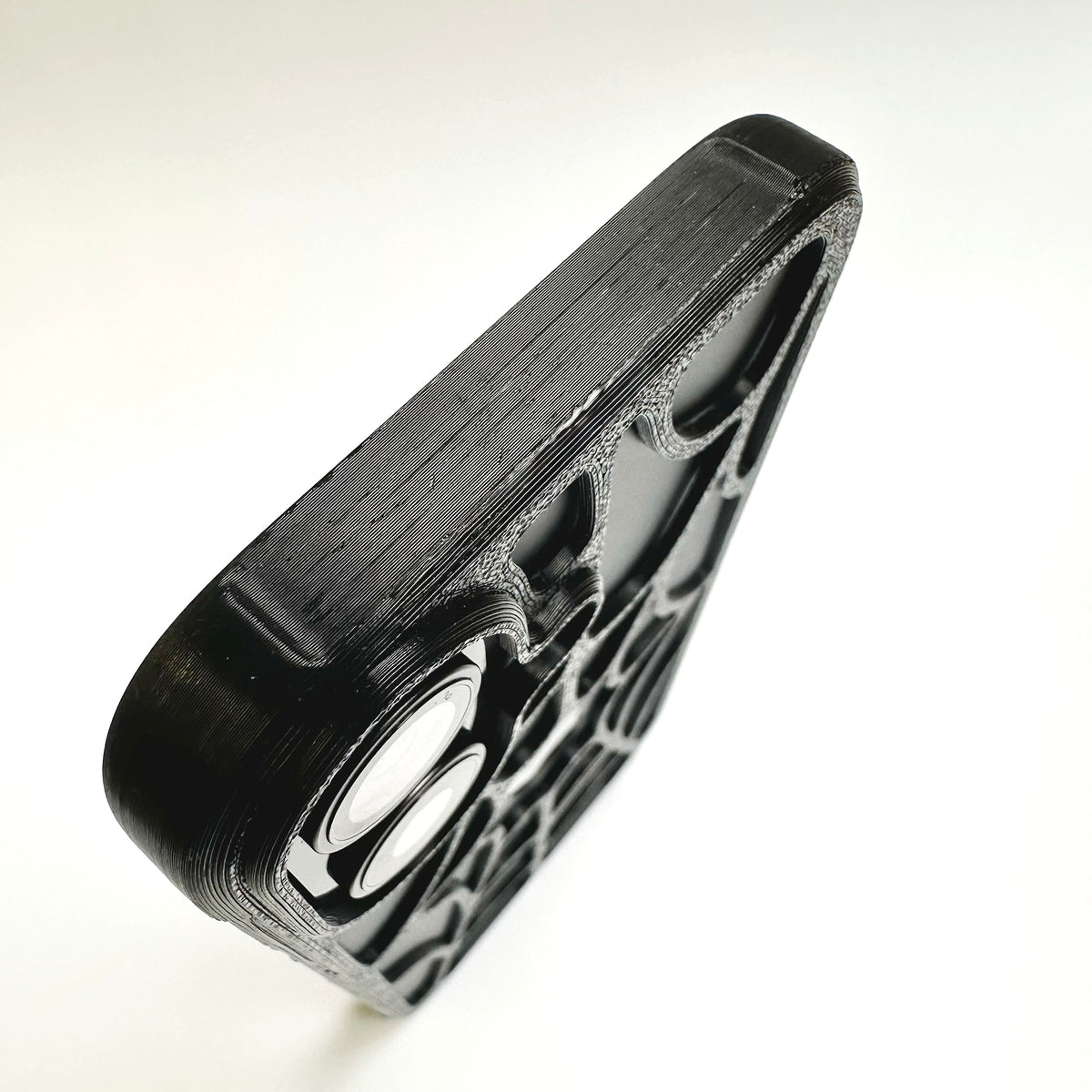 Corner and camera cutout detail of a black 3D-printed spiderweb iPhone case