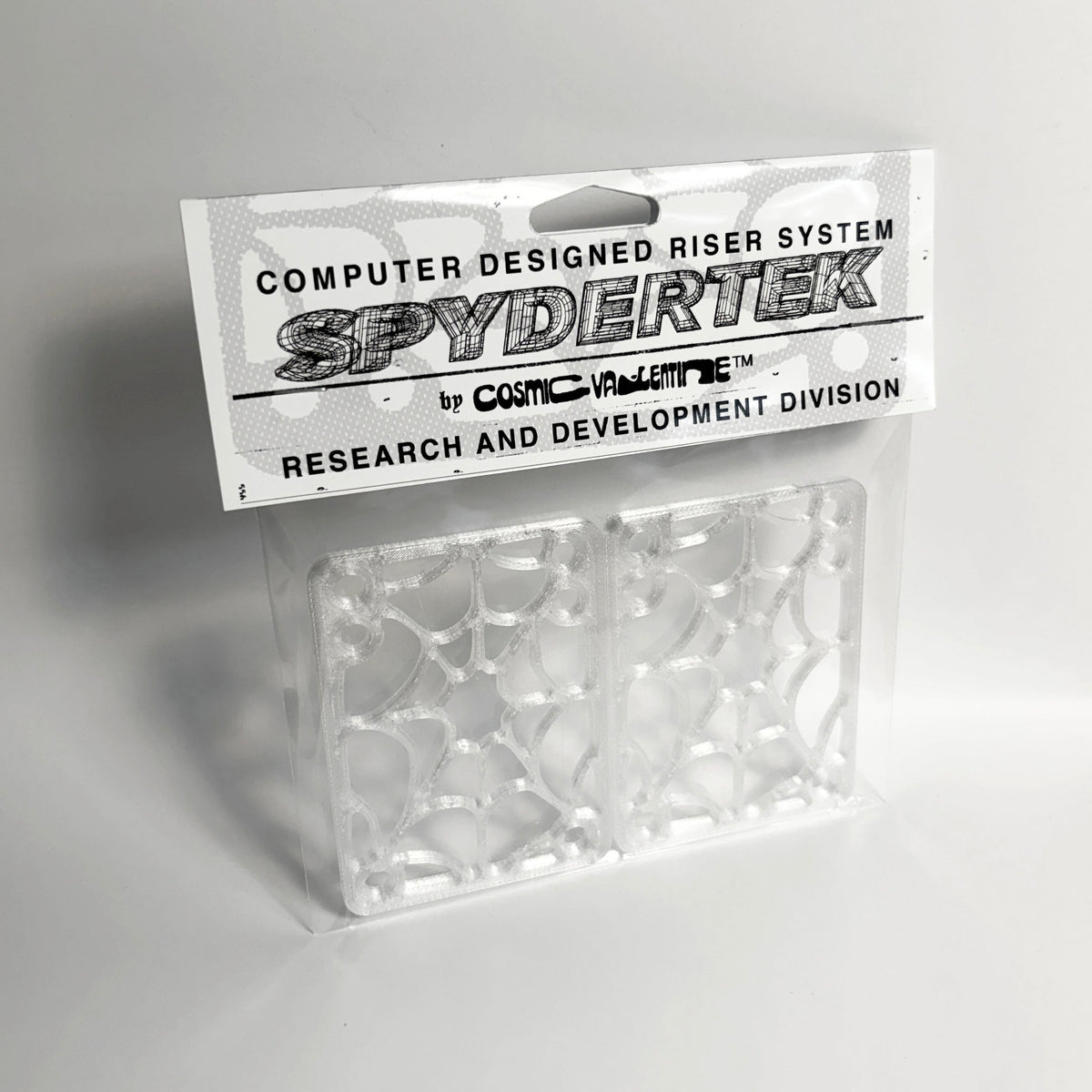 Two transparent skateboard riser pads with a web-like pattern in clear packaging, labeled "SPYDERTEK" at the top.