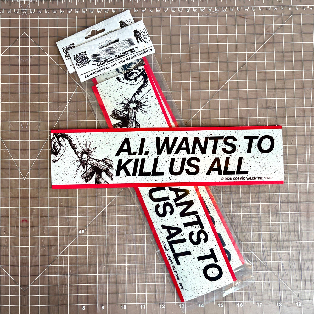 A.I. Wants to Kill Us All vinyl sticker, 12 × 3 in, on a cutting mat with packaged stickers