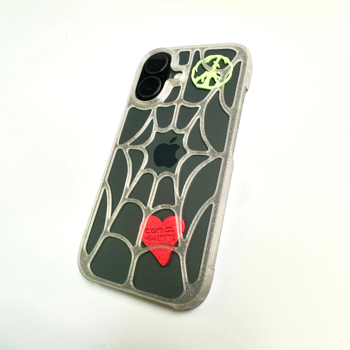 Spiderweb iPhone case with a red heart and green peace piece, angled view on a phone